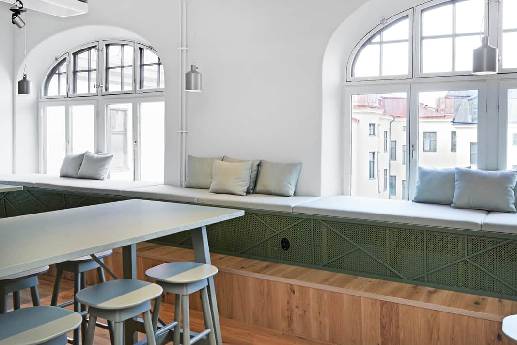 Platsbyggda sittbänkar i matsal.