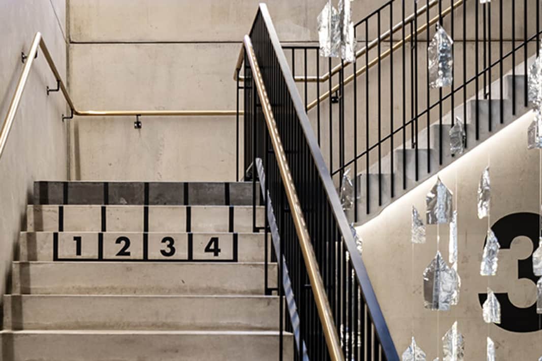 Trappa med utsmyckningar och svart räcke.