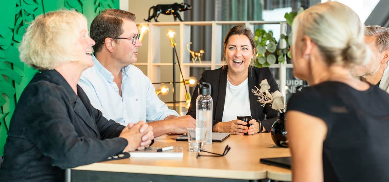 Skrattande personer runt ett bord