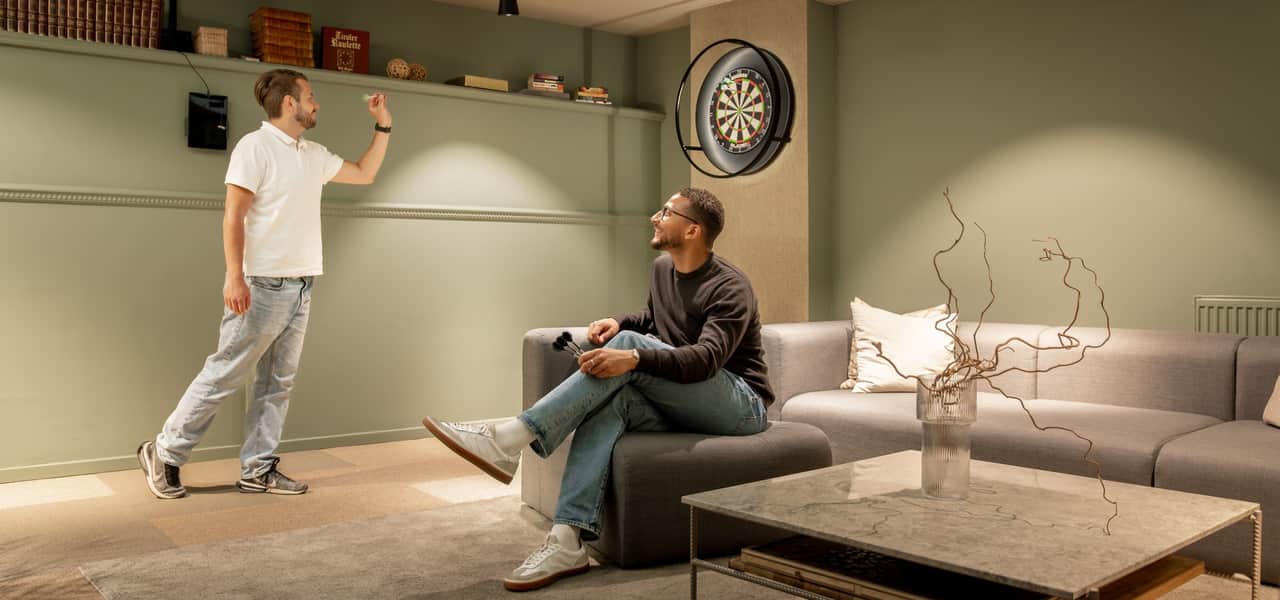 Två personer kastar pil på kontoret