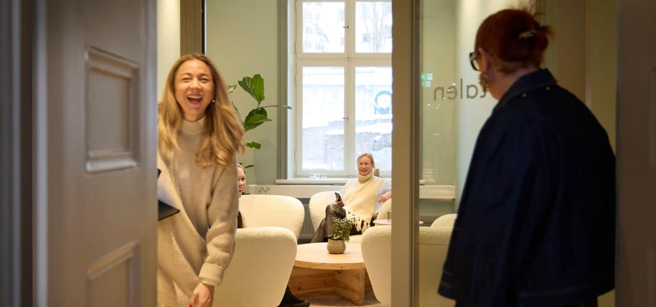 Tre personer i ett mötesrum.