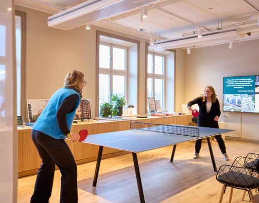 Två medarbetare spelar pingis.