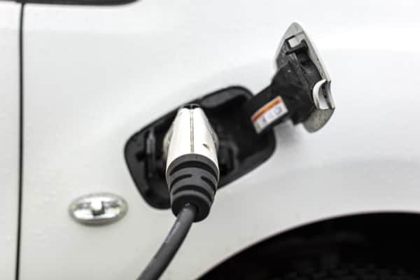 Vit bil med elladdare isatt