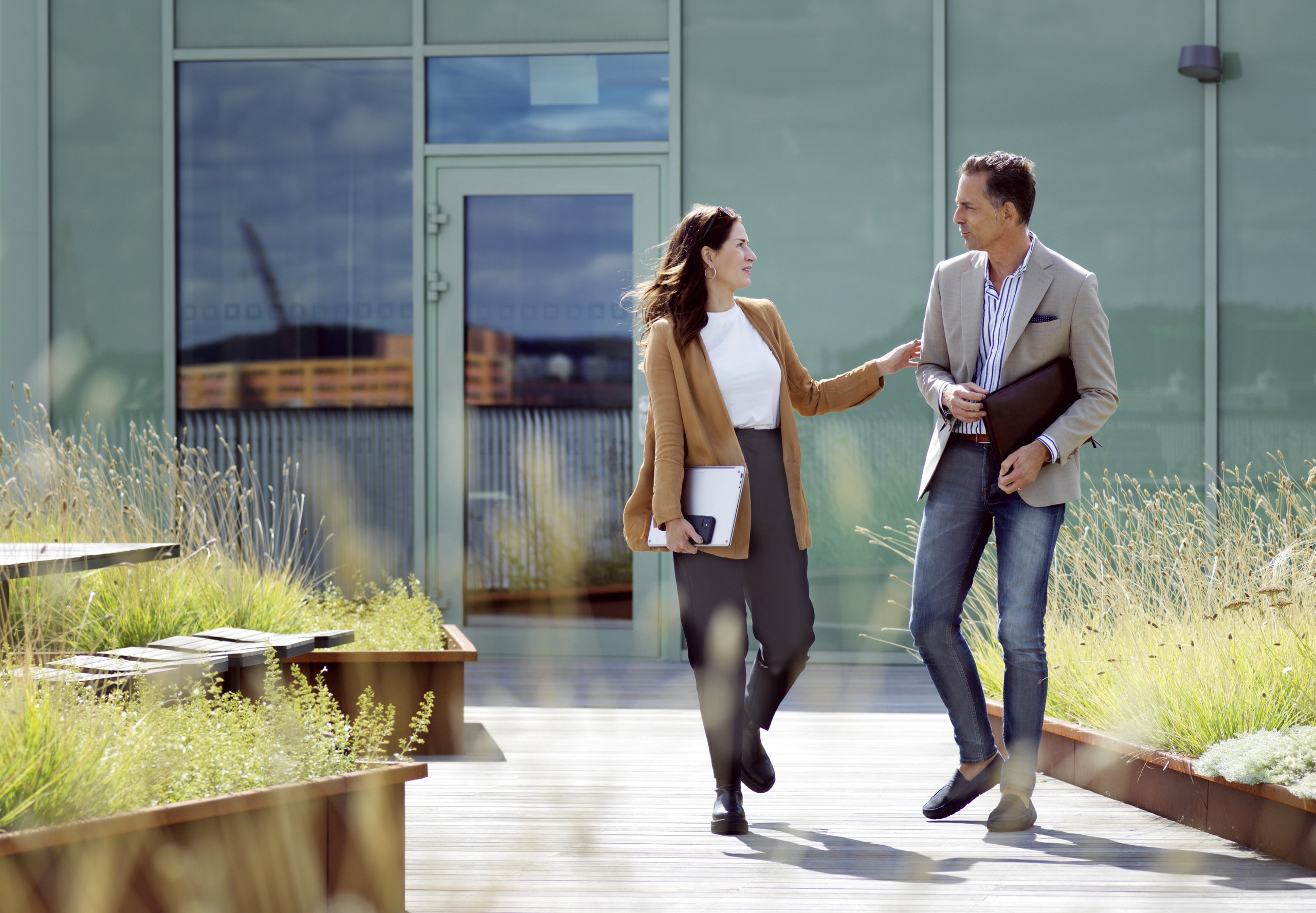 Två personer som går på en takterrass.