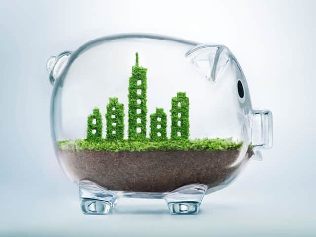 Spargris i glas med gröna byggnader inuti.