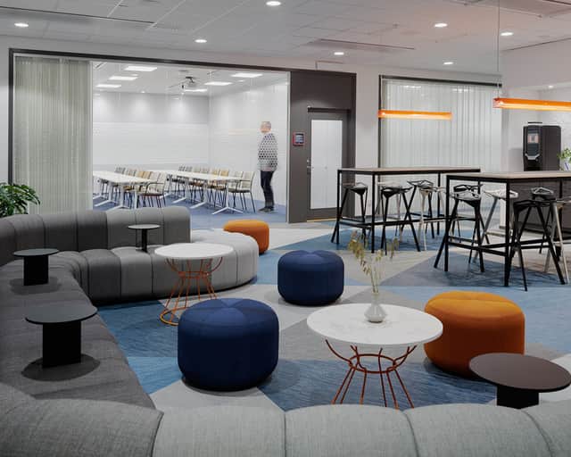 Vy över soffgrupp med höga bord och ett mötesrum i bakgrunden.