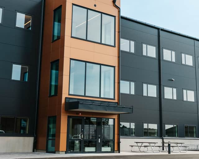 Svart fasad med orangefärgat fasadparti vid ingången