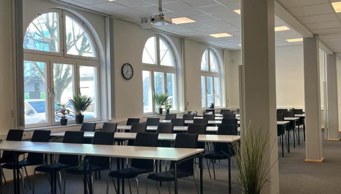 Ett rum fyllt med många bord och stolar.