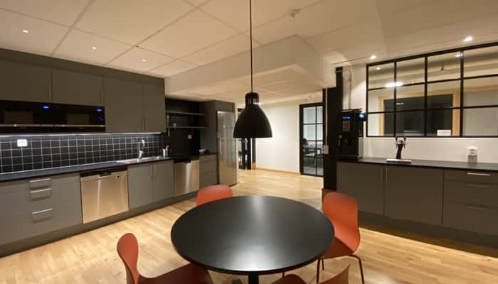 Ett kök med bord, stolar och diskho.