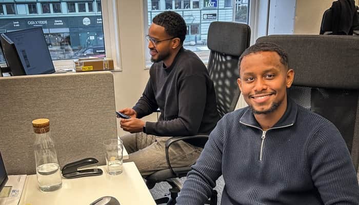 Tvp män sitter framför en bärbar dator.