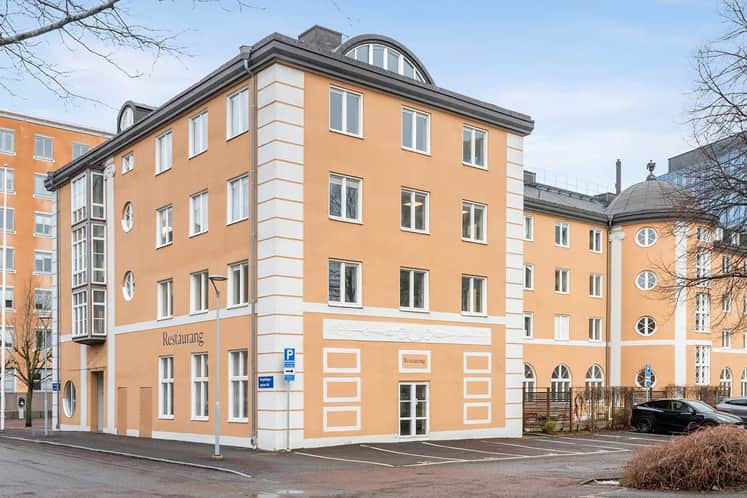 En stor orange byggnad som ligger i hörnet av en gata.