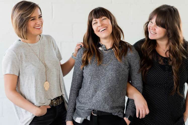 Tre personer som håller om varandra.