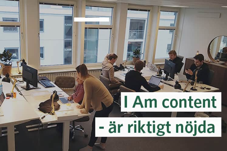 Interiörbild av kontoret och människor som jobbar vid skrivbord.