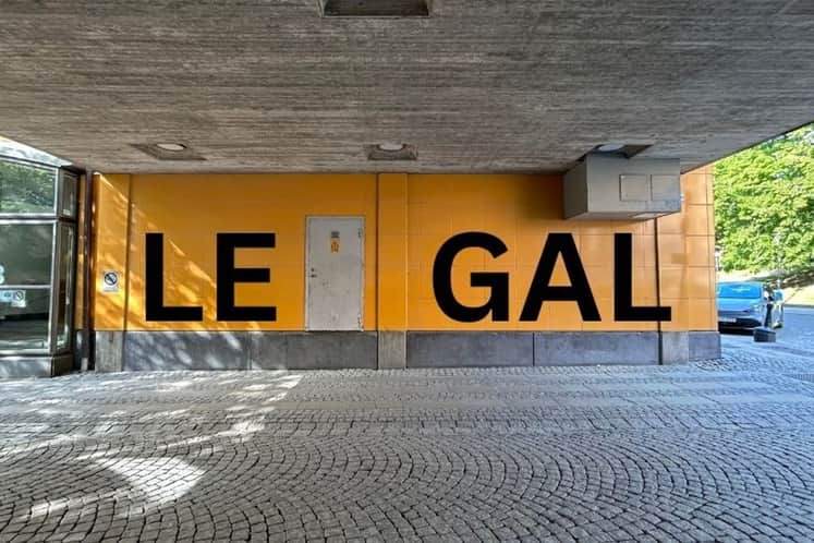 Orangefärgad vägg med texten LEGAL i stora bokstäver i svart färg
