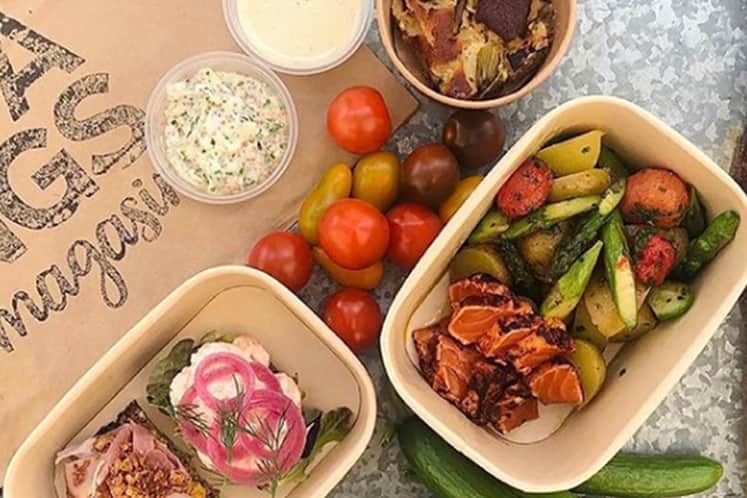 Matförpackningar på ett bord med grönsaker.