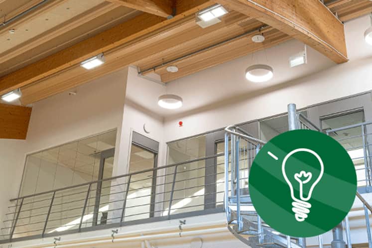 Interiörbild från lokalen med pålagd grafik föreställandes glödlampa.