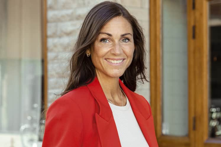 Närbild på kvinna med långt brunt hår och röd kavaj