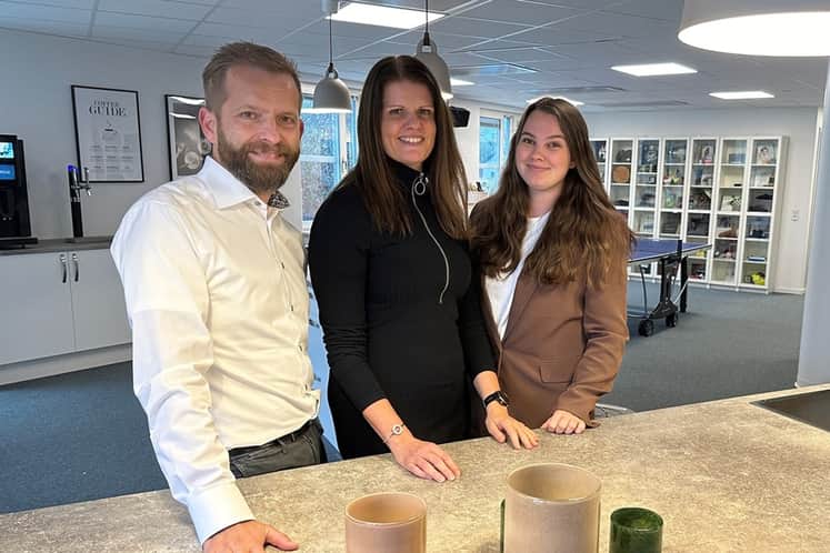 Bild från Nordlos kontor med tre anställda ståendes vid en bänkyta.