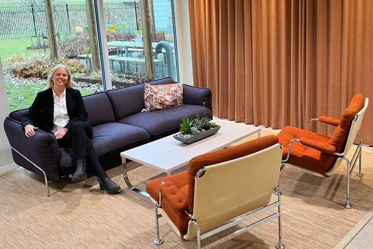 Lovisa sitter i en återbrukad soffa i en lounge