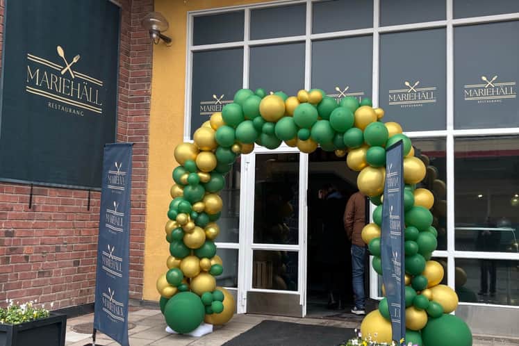 Bild på entrén till restaurangen från invigningen med ballongbåge