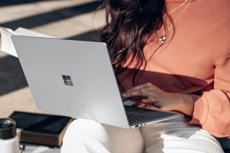 Person med laptop i sitt knä.