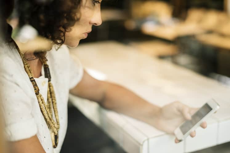 Person sitter med en telefon.