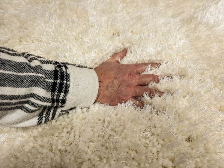 Hand stryker en luden vit matta