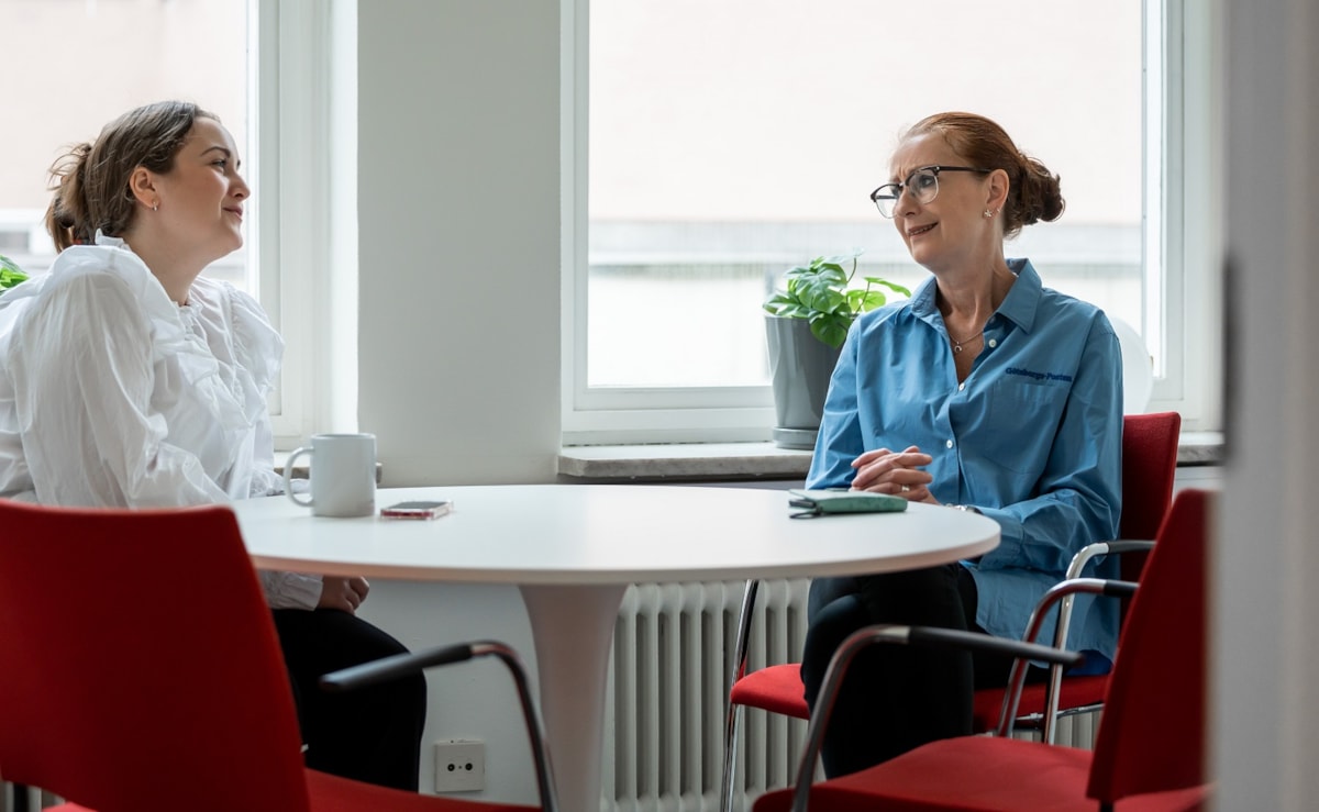 Tv&aring; personer vid ett bord.