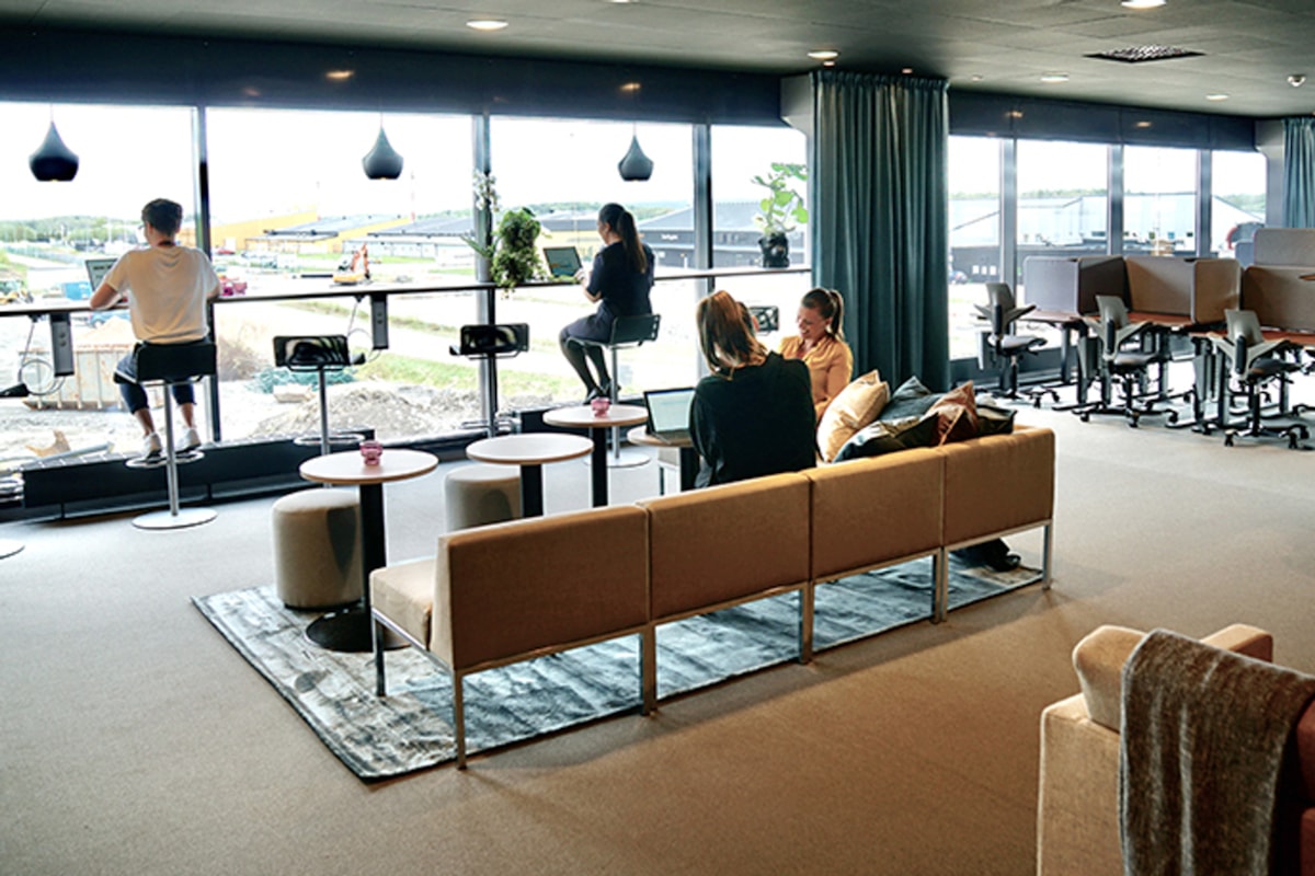 Interi&ouml;rbild av kontorslokalen med m&auml;nniskor som sitter och jobbar.