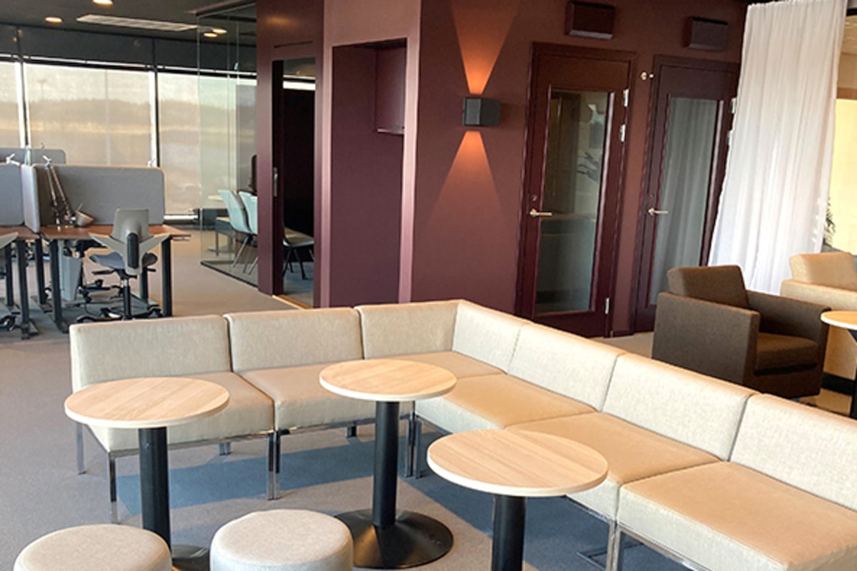 Interi&ouml;rbild av kontorsmilj&ouml; med soffgrupp i f&ouml;rgrunden.