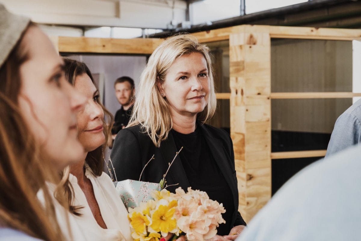 Tre personer varav en h&aring;ller i en blombukett.