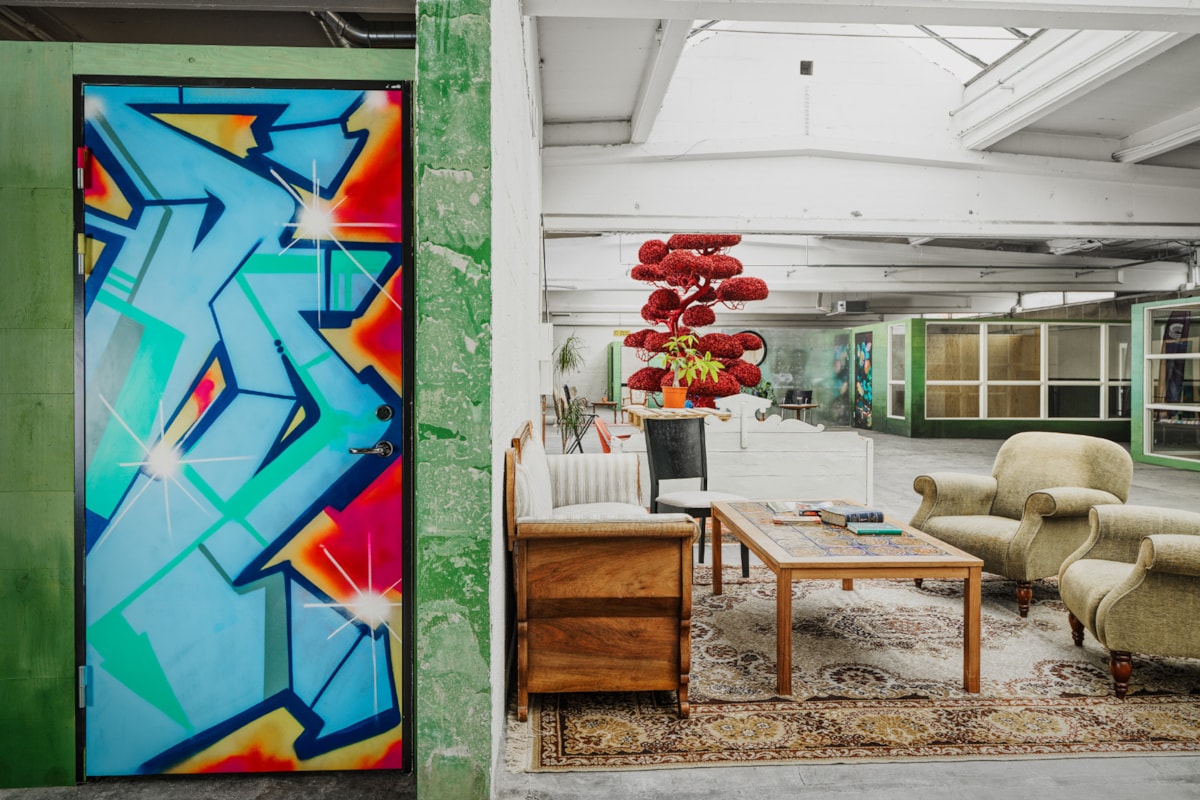 Interi&ouml;rbild med graffitim&aring;lad d&ouml;rr och soffgrupp.