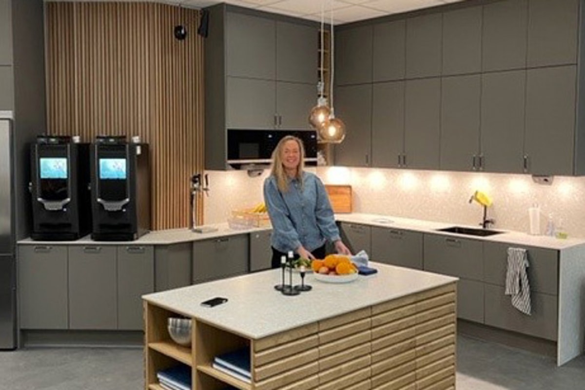 En person st&aring;r vid k&ouml;ks&ouml; i k&ouml;ket.