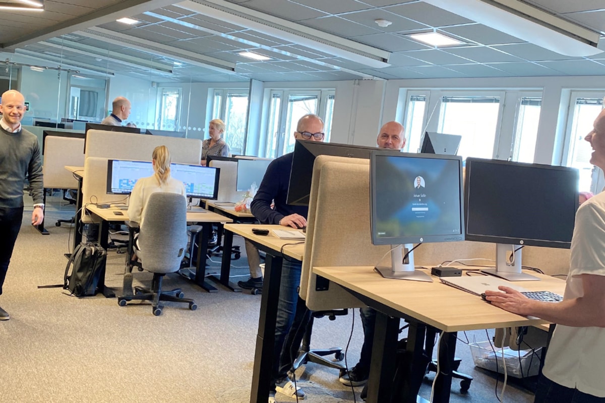 Interi&ouml;rbild med m&auml;nniskor vid skrivbord.