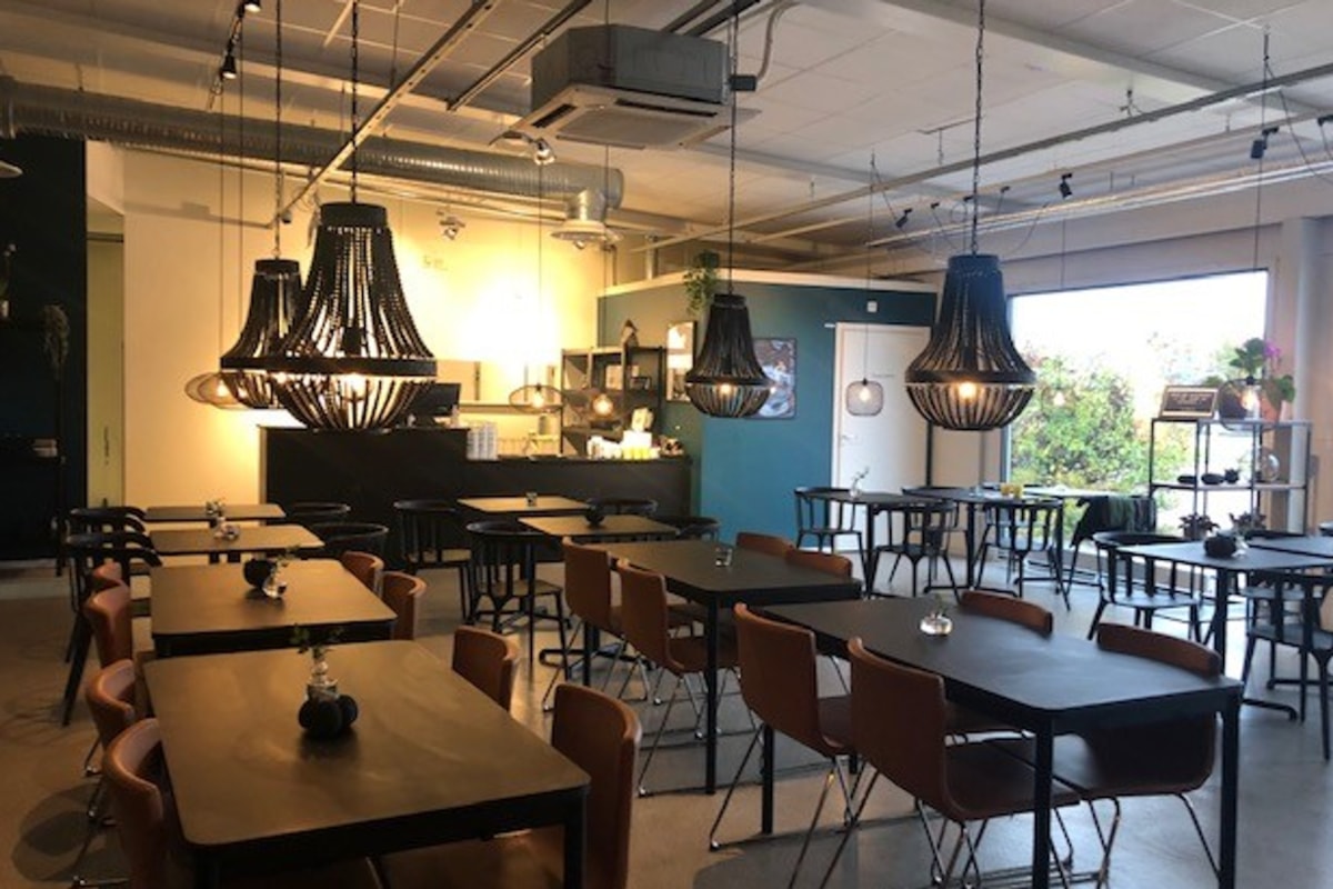 Vy &ouml;ver matsalen med svarta takkronor &ouml;ver borden.