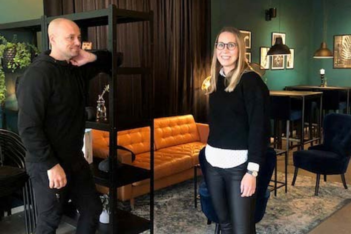 Johan och en person till st&aring;r vid en soffgrupp.