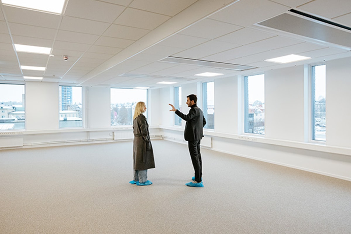 Tv&aring; personer st&aring;r i den tomma lokalen.