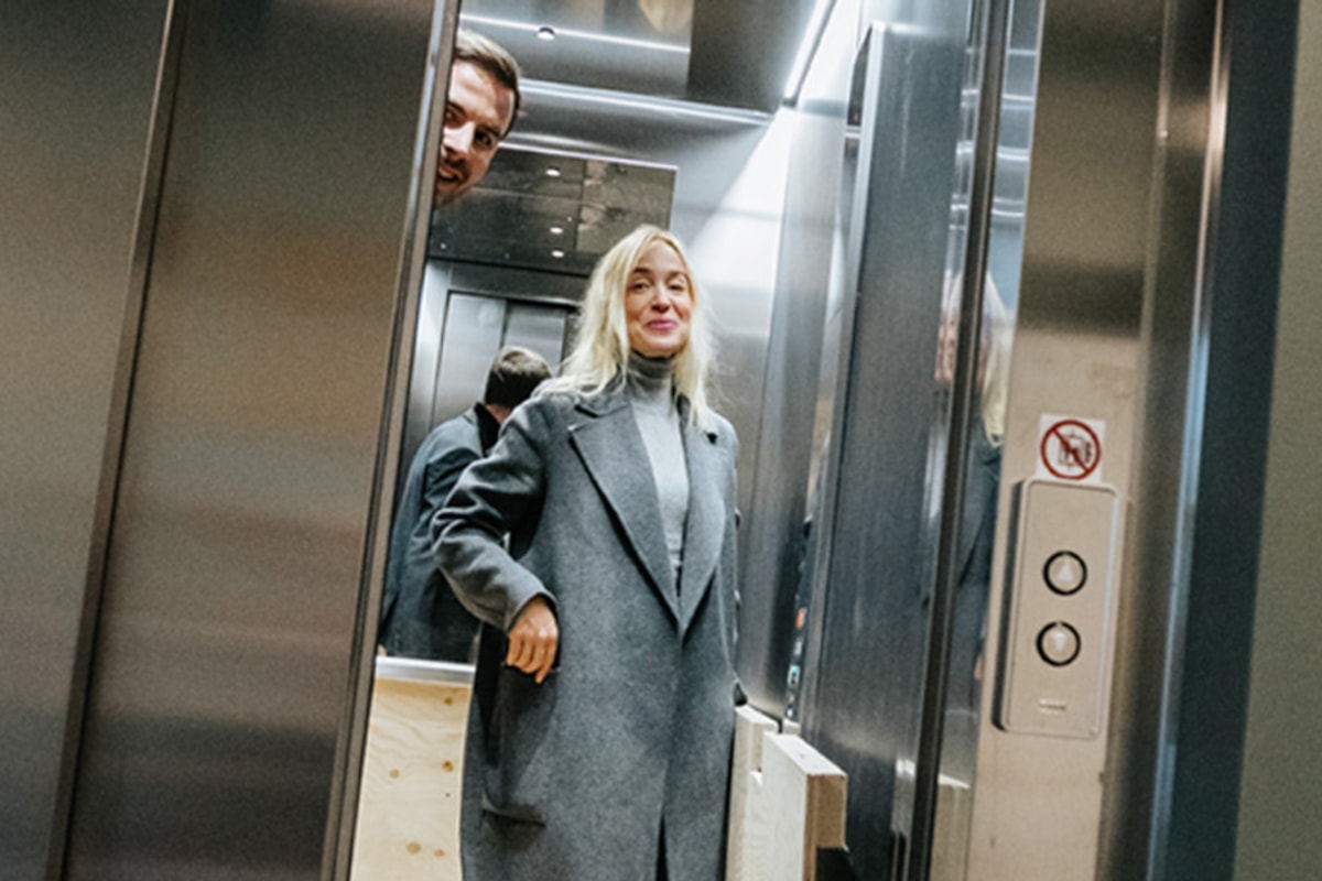 Charlotta st&aring;r inne i en hiss.